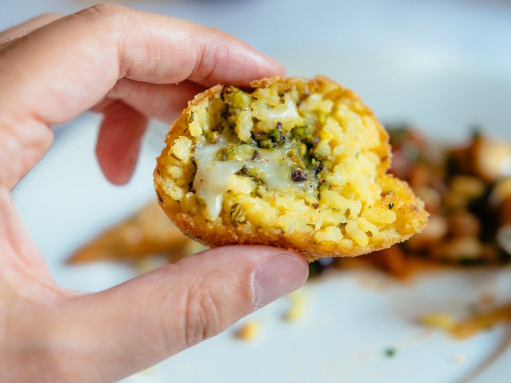 Roman arancini with pistachio and saffron are rice balls with a creamy saffron-infused rice, stuffed with pistachio, and deep-fried to perfection.