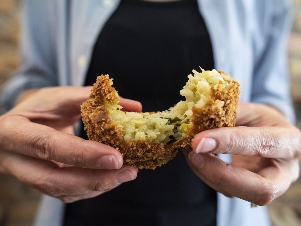 Supplì are Roman street food delicacies, deep-fried rice croquettes typically filled with ragù (meat and tomato sauce) and mozzarella, creating a crispy exterior and a gooey, flavorful centre.