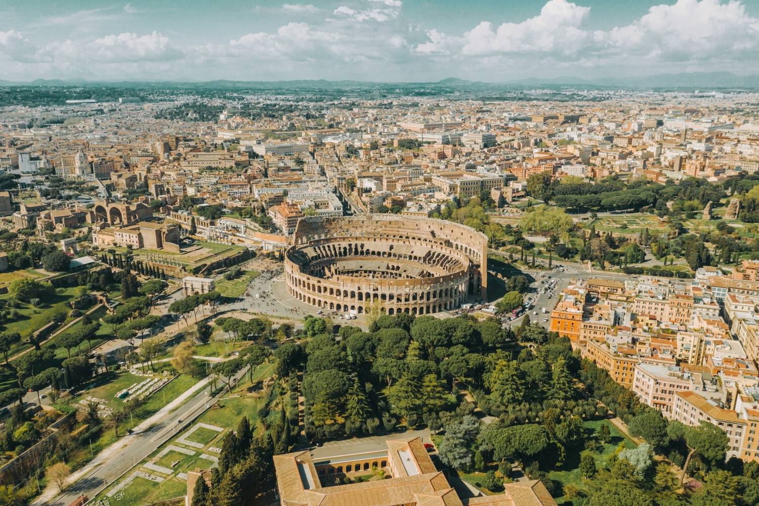 An aerial shot of the Colosseum in Rome which captures the great scenery and nature